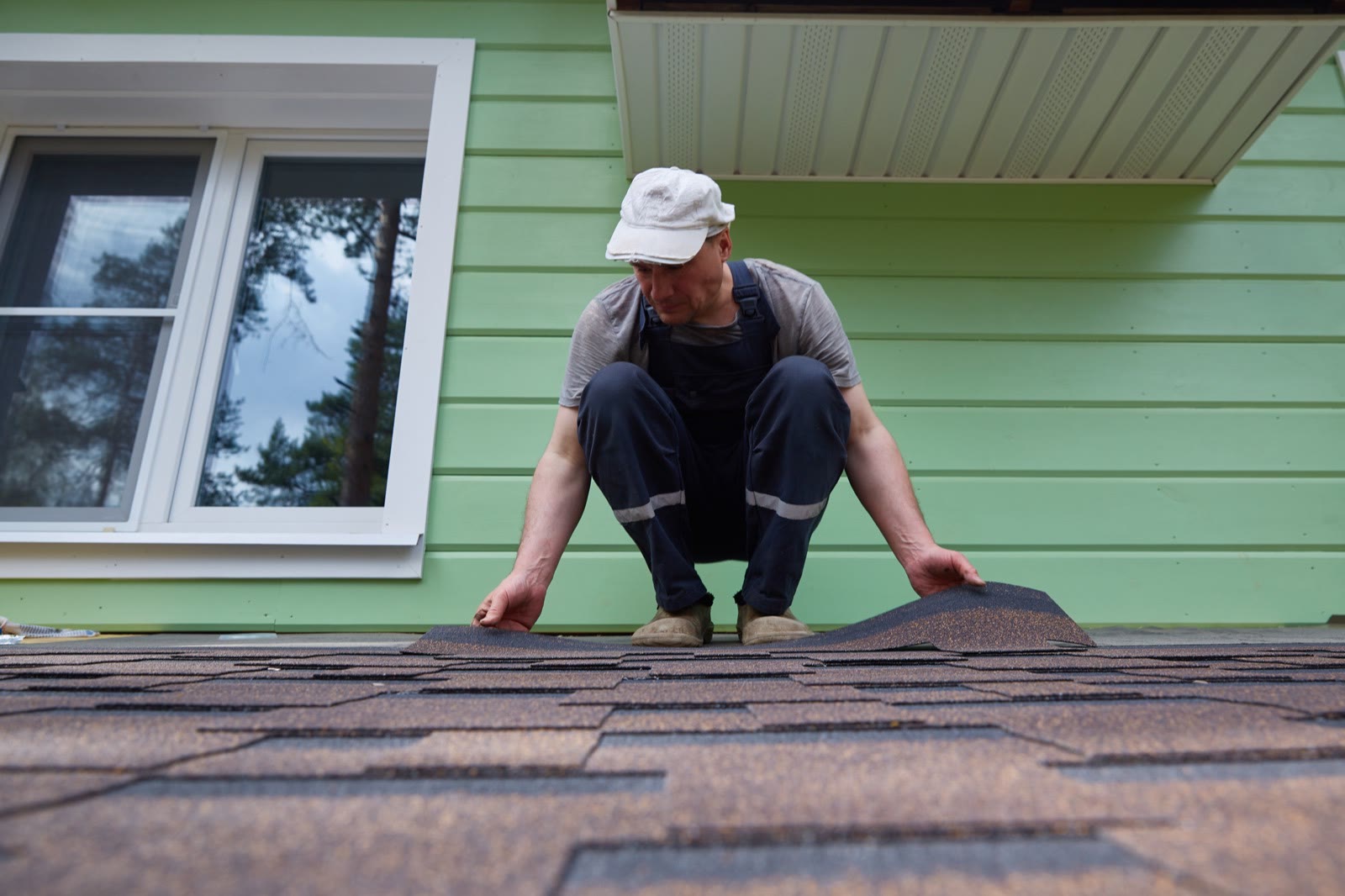 Roofer laying shingles on a residential roof